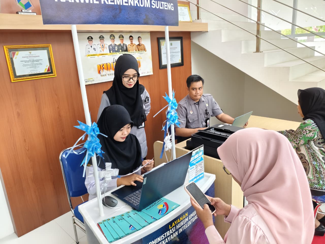 Petugas Kanwil Kemenkum Sulteng melayani masyarakat dalam pengurusan legalitas badan usaha melalui Agensi Layanan AHU di Kabupaten Banggai, mempermudah pendaftaran PT Perorangan dan layanan Administra