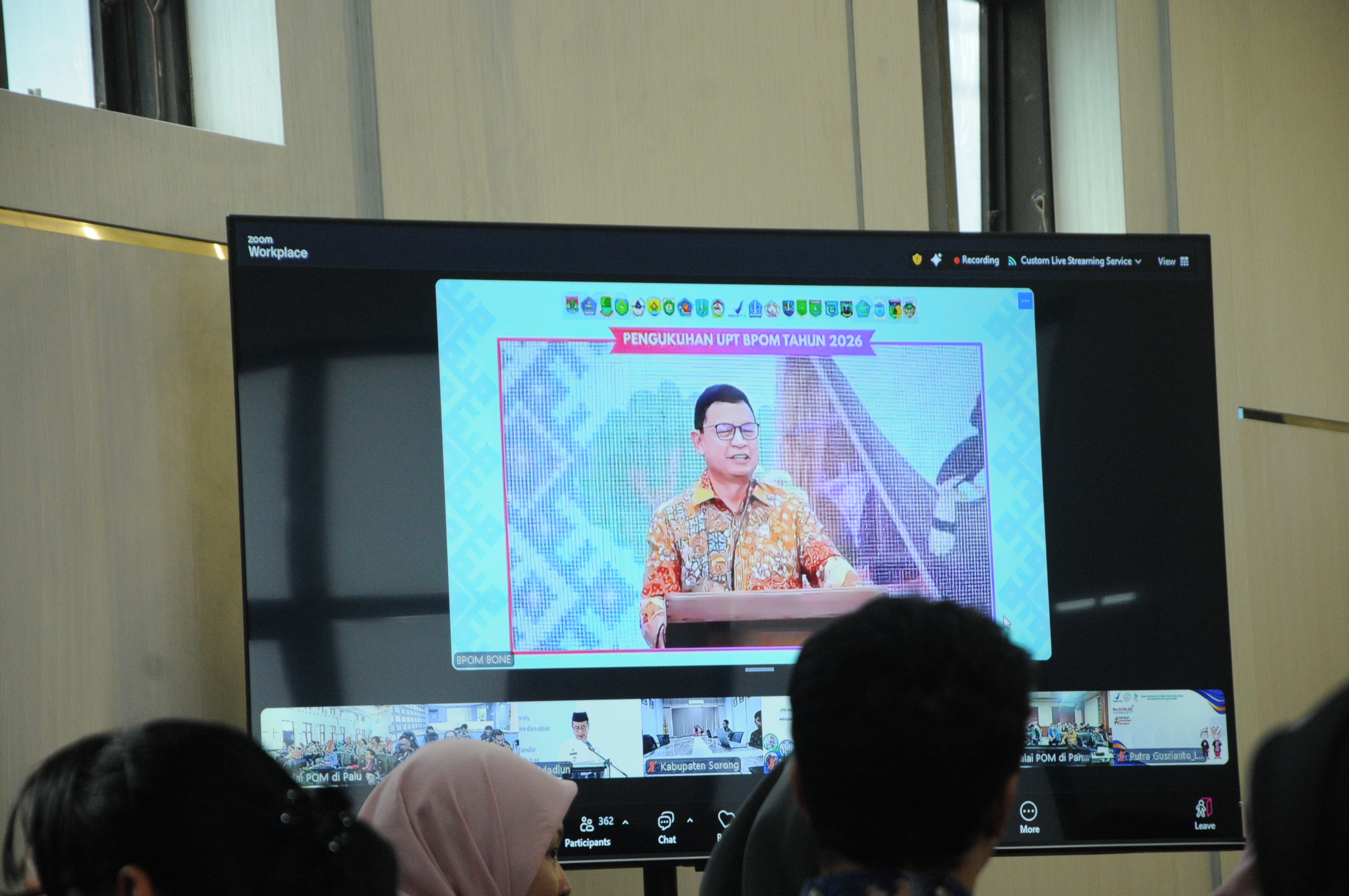 Tamu undangan yang mengamati dari layar monitor saat Kepala Badan Pengawas Obat dan Makanan (BPOM) RI Prof. dr. Taruna Ikrar memberi sambutannya dalam peresmian UPT BPOM yang baru.