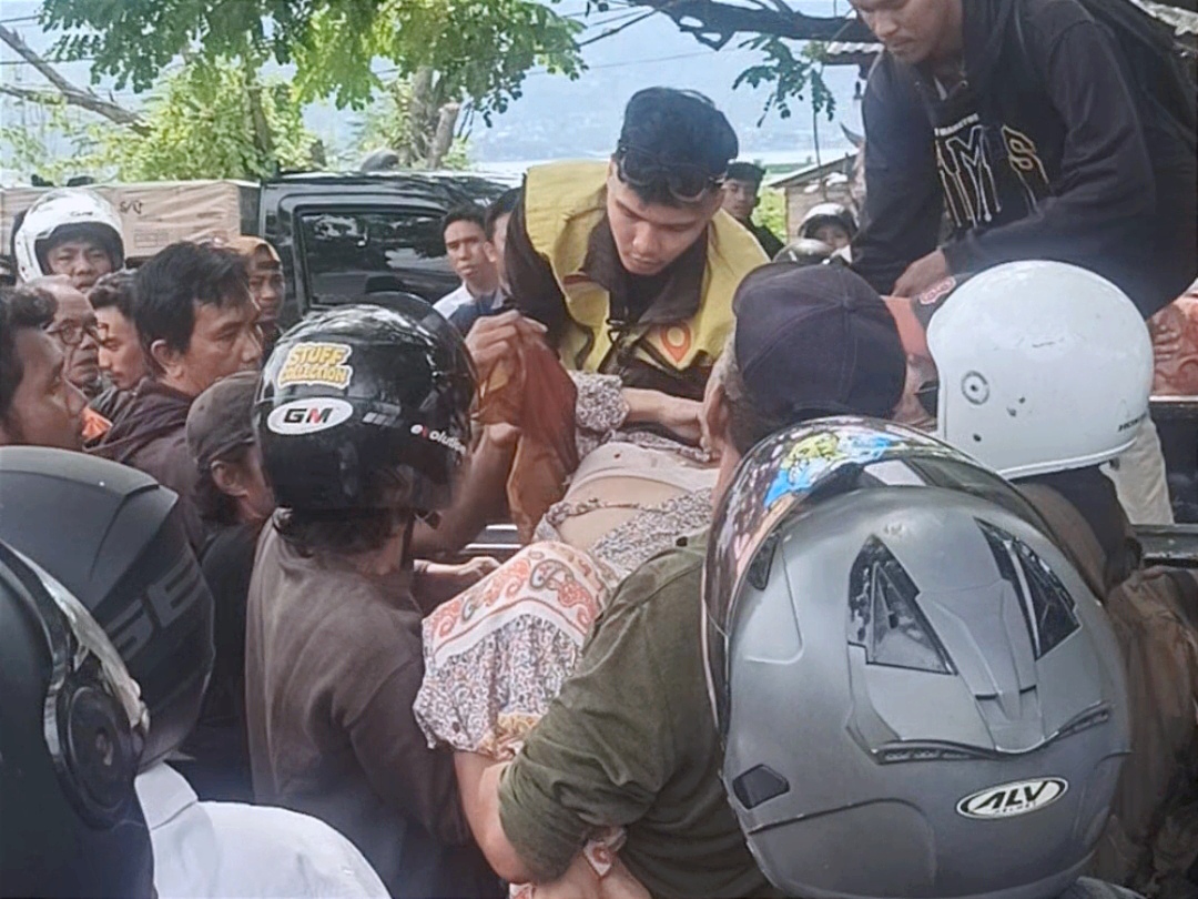 Warga mengevakuasi pengemudi mobil Raize merah yang mengalami luka serius akibat kecelakaan beruntun di Jalan Yos Soedarso, Rabu (11/3), menggunakan mobil pikap untuk dilarikan ke RS Undata Palu.