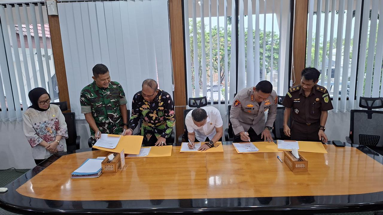 Wali Kota Palu menandatangani kerja sama optimalisasi pajak daerah bersama aparat penegak hukum di ruang kerja wali kota.