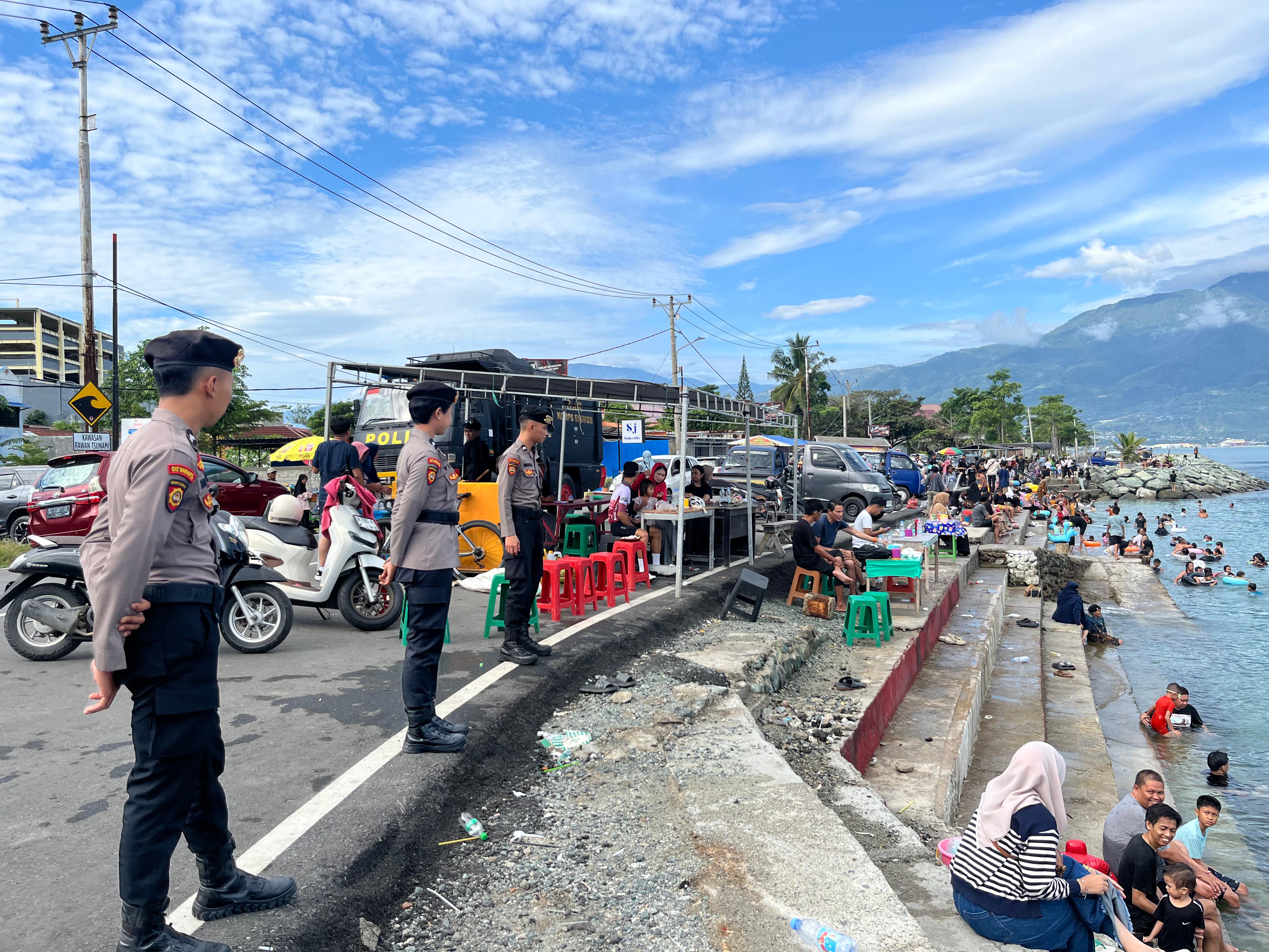 Personel kepolisian melaksanakan patroli dan pengamanan di kawasan Kampung Nelayan Talise, saat libur Lebaran 1447 Hijriah, Minggu (22/3/2026).