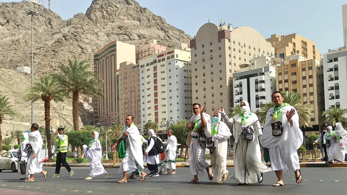 SELESAI UMRAH: Calon jemaah haji di Indonesia menyeberang jalan di kawasan Mahbas, Makkah, setelah beribadah di Masjidilharam kemarin. (NAUFAL WIGI/JAWA POS)