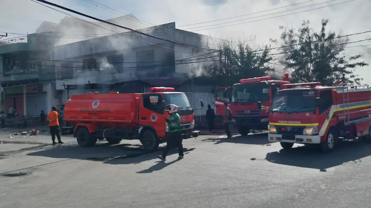 Petugas pemadam kebakaran berjibaku memadamkan api yang melalap ruko dua lantai di Jalan Danau Lindu, Kelurahan Ujuna, Kecamatan Palu Barat, Selasa (7/4/2026).