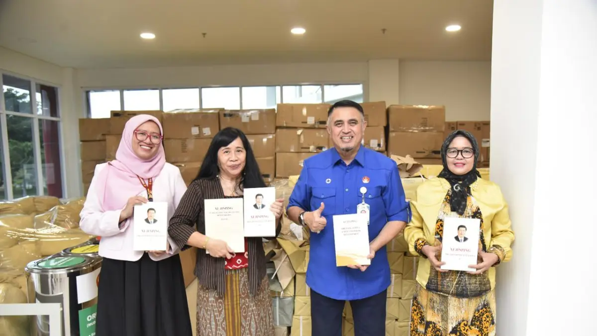 Rektor Untad menunjukkan koleksi buku hibah dari Pemerintah Tiongkok di perpustakaan kampus. (IstimewaRadar Palu)