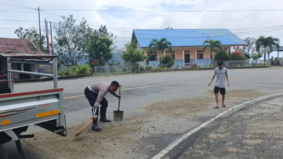 MEMPERBAIKI: Tampak salah seorang personel Satlantas yang bertugas di wilayah Kebun Kopi, sedang memperbaiki fasilitas jalan raya.(FOTO: ISTIMEWA/RADAR PALU)