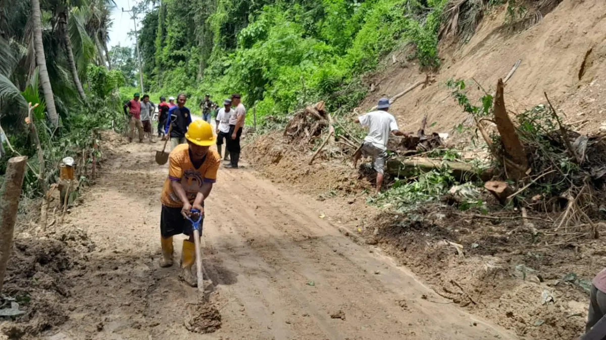LONSOR: Warga dan aparat terlihat bahu membahu membersihkan jalan, usai tertimbun longsor.(FOTO: NENDRA PRASETYA/RADAR PALU).