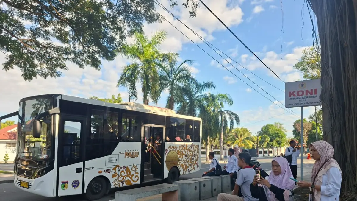 ASN Palu memadati halte depan Rujab wali kota—menunggu bus sambil menggenggam ponsel untuk absensi pagi. (Annisa Tri YusnidaRadar Palu)