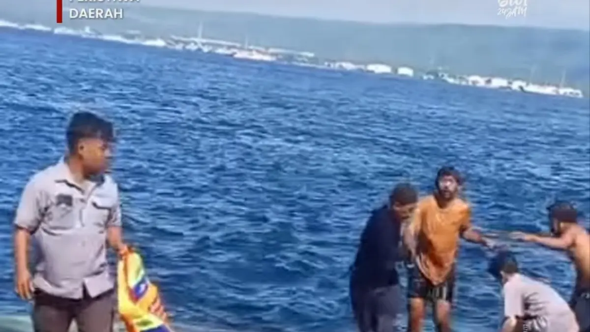 Detik-detik pria bertahan di tengah Selat Bali—terlihat kecil di antara ombak, sebelum akhirnya diselamatkan kru kapal.(Banyuwangi24iam)