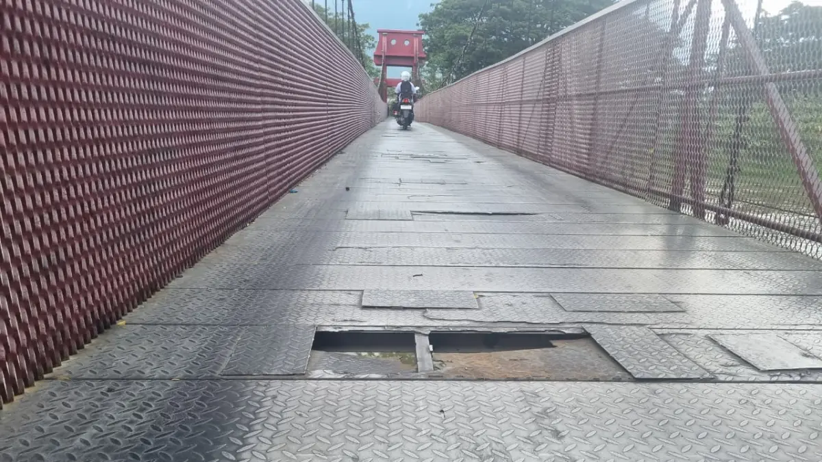HATI-HATI: Plat besi lantai Jembatan Gantung Nunu–Lolu Utara kembali berlubang, membahayakan pengendara roda dua. FOTO: MOH FATHAHILA 
