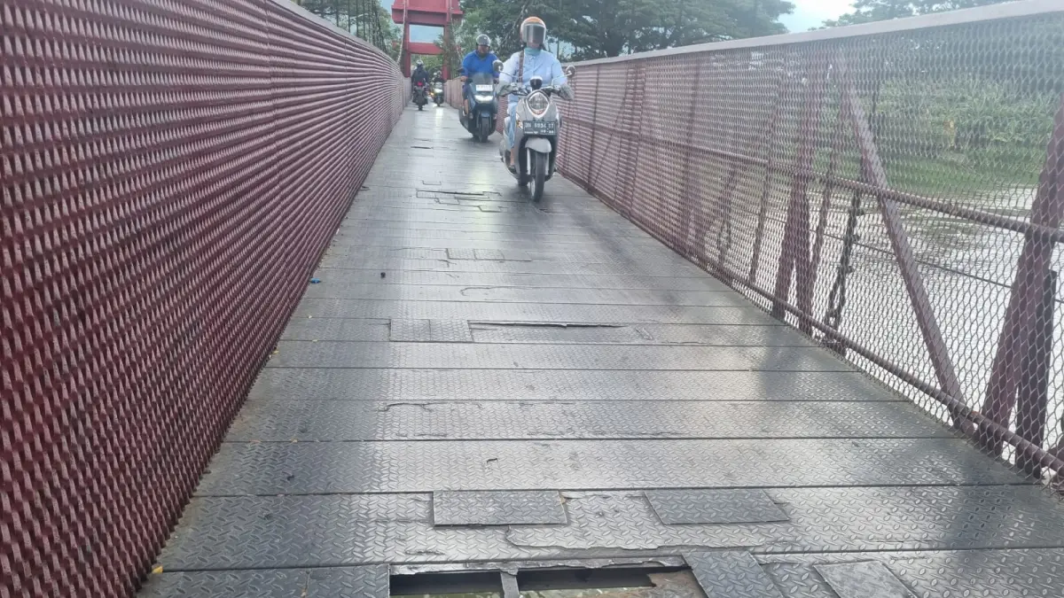 RUSAK LAGI: Plat besi lantai Jembatan Gantung Nunu–Lolu Utara kembali berlubang, membahayakan pengendara roda dua. FOTO: MOH FATHAHILA 