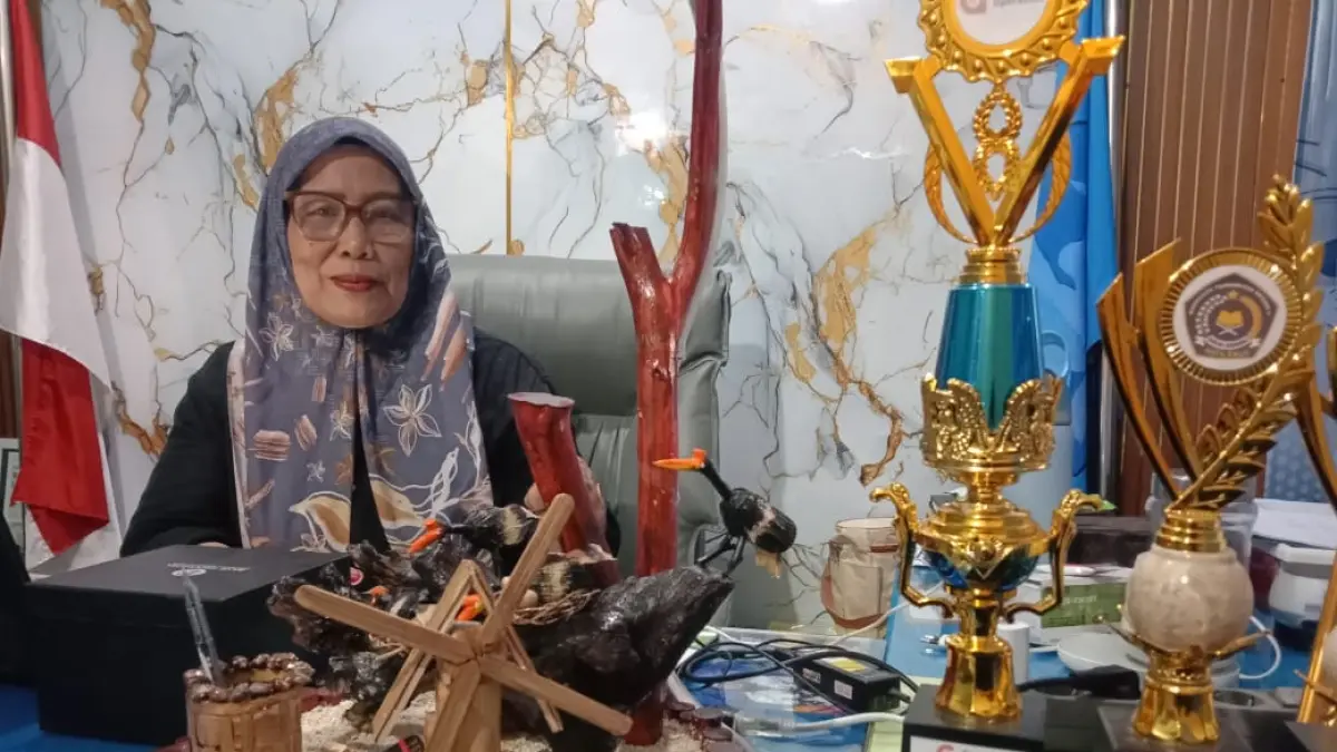 Kepala SDN 3 Palu, Dutri, bersama karya kriya kincir angin karya siswanya. (Ade Safitri/Radar Palu)