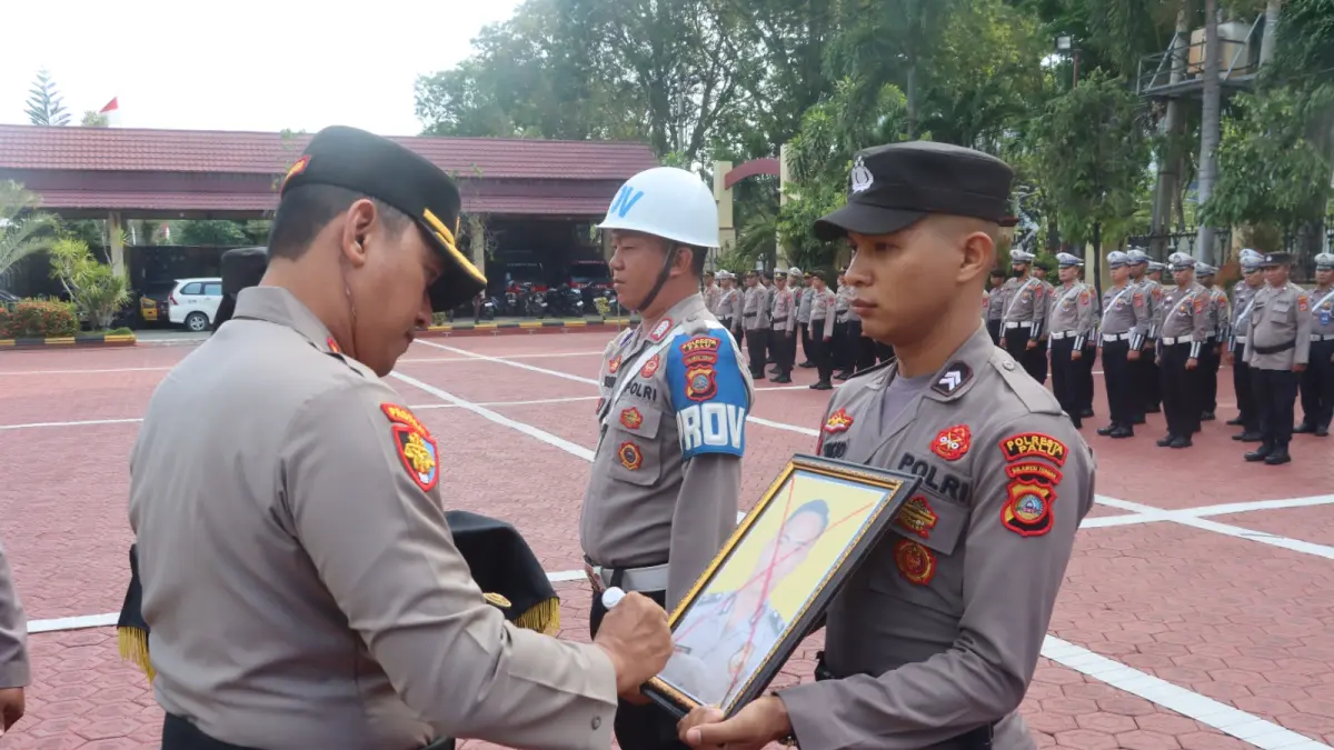 Pejabat Polresta Palu melakukan pencoretan foto personel saat upacara Pemberhentian Tidak Dengan Hormat (PTDH) di Mapolresta Palu.