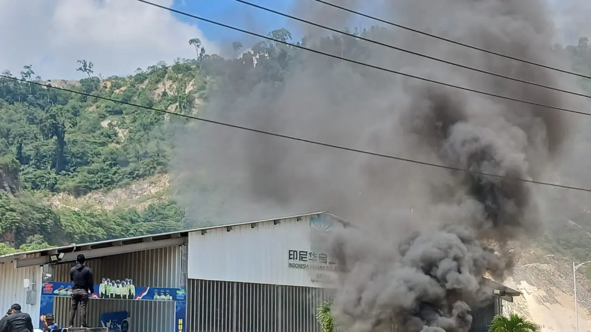 BAKAR BAN: Asap mengepul di udara, massa aksi membakar ban untuk mencari perhatian pihak manajemen PT. IHIP.(FOTO: SUPRIYONO/RADAR PALU).