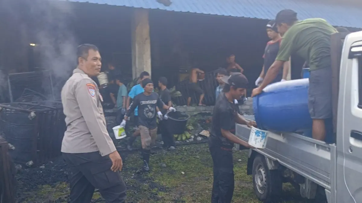 KEBAKARAN: Polisi dan warga evakuasi barang berharga usai PT Eco Coco terbakar.(FOTO: NENDRA PRASETYA/RADAR PALU).