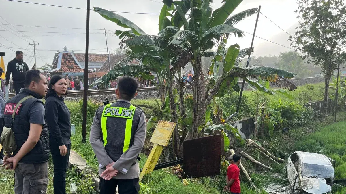 Petugas kepolisian bersama warga meninjau lokasi kecelakaan mobil yang terperosok ke area persawahan di dekat perlintasan kereta api tanpa palang pintu di wilayah Kabupaten Grobogan, Jawa Tengah, Jumat (1/5/2026). (HO - Polres Grobogan)&nbsp;