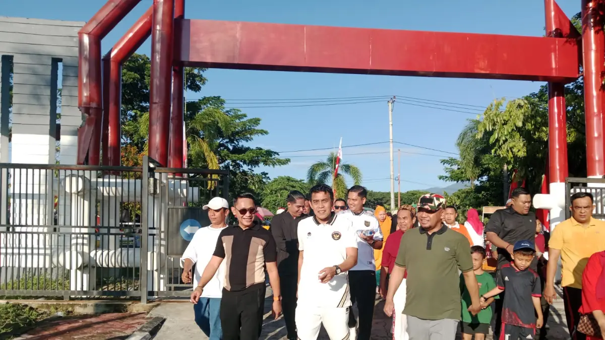 AKSI SOLIDARITAS : Bupati Parigi Moutong H. Erwin Burase berjalan bersama anggota Laskar Merah Putih dan masyarakat saat mengikuti jalan santai kebangsaan di halaman Kantor Bupati Parigi Moutong, Minggu (3/5/2026).(FOTO: ISTIMEWA/RADAR PALU).