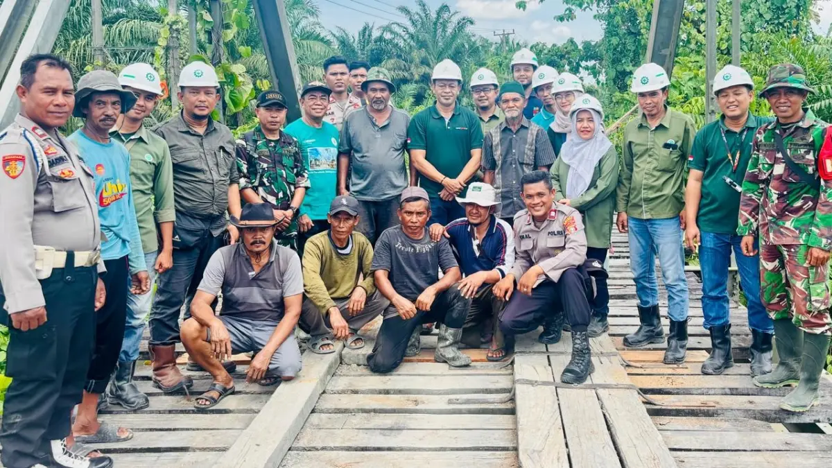 Warga Desa Minti Makmur dan Desa Bukit Indah bersama PT Lestari Tani Teladan, Koramil, serta Polsek Kecamatan Rio Pakava usai gotong royong memperbaiki jembatan penghubung antar desa yang rusak parah.