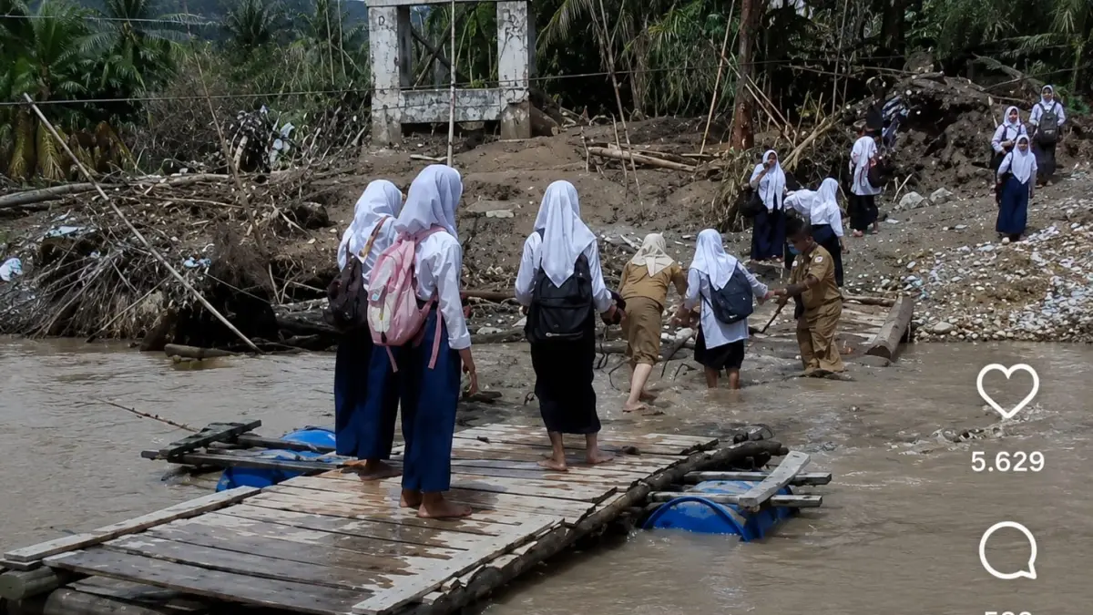 Siswa menyeberangi sungai menggunakan jembatan rusak di Desa Reje Payung, Aceh Tengah.(Instagram @serta_lia_gali)