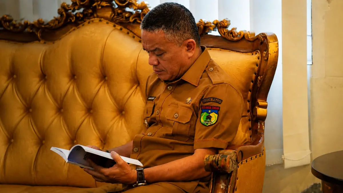 Potret hangat Hadianto Rasyid saat menelaah buku karya K.H Zainal Abidin tentang perjalanan pembangunan Kota Palu.
