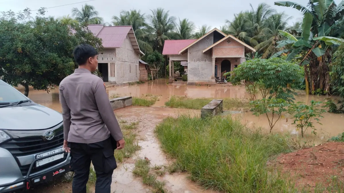 BANJIR GUNUNG SARI: Personel Polsek Bolano Lambunu bersama warga melakukan pemantauan di lokasi banjir yang merendam puluhan rumah di Desa Gunung Sari, Kecamatan Bolano Lambunu, Selasa (19/5/2026).(FOTO: ISTIMEWA/RADAR PALU)