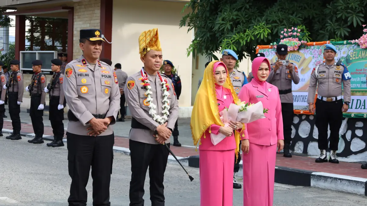 Brigjen Pol. Nasri bersama Ketua Bhayangkari Daerah Sulteng, Ny. Lina Nasri, menerima penyambutan adat Kaili melalui tradisi pedang pora serta pemasangan siga dan sampolu saat tiba di Mako Polda Sulteng, Rabu (20/5/2026).