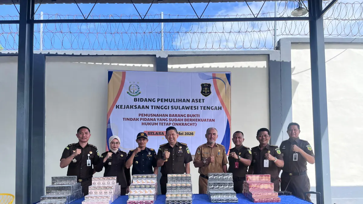 Petugas Kejaksaan Tinggi Sulawesi Tengah bersama unsur terkait berfoto di depan barang bukti jutaan batang rokok ilegal tanpa pita cukai sebelum dimusnahkan di Rupbasan Palu, Selasa (19/5/2026).