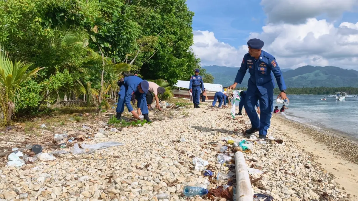 AKSI: Personel Satpolairud Polres Parigi Moutong bersama perangkat Desa Lebo dan masyarakat melakukan aksi bersih-bersih sampah di kawasan pesisir Pantai Desa Lebo, Kecamatan Parigi, Kamis (21/5/2026).(FOTO: RAHMAT FADHIL/RADAR PALU)