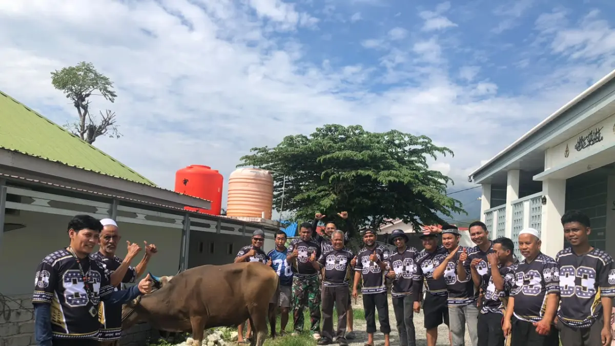 SEMANGAT BERKURBAN: Panitia kurban Masjid Nur Ash Shiyaam, Perumahan Green Gawalise Mandiri, Kelurahan Duyu, berfoto bersama dengan hewan kurban usai salat Iduladha, Rabu (27/5/2026). Tahun ini ada 8 ekor sapi dikurbankan. FOTO: NUR SOIMA ULFA

