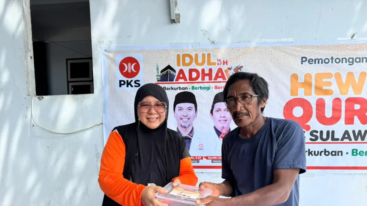 BERBAGI: Bunda Wiwik saat menyerahkan paket kurban kepada salah seorang warga, yang tinggal di dekat kantor DPW PKS Sulteng, Jln. Sisingamangaraja, Kota Palu.(FOTO: ISTIMEWA/RADAR PALU).
