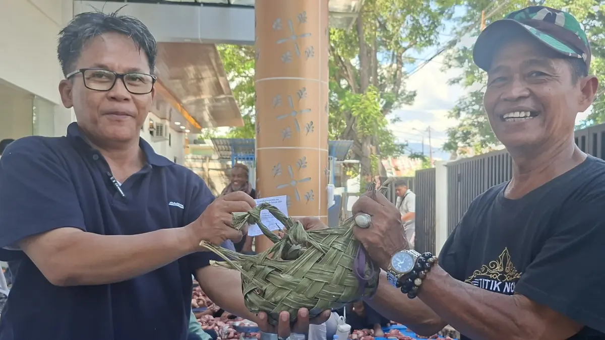 Petugas DLH Kota Palu menyerahkan daging kurban menggunakan kantong ramah lingkungan.(Annisa Tri Yusnida/Radar Palu)