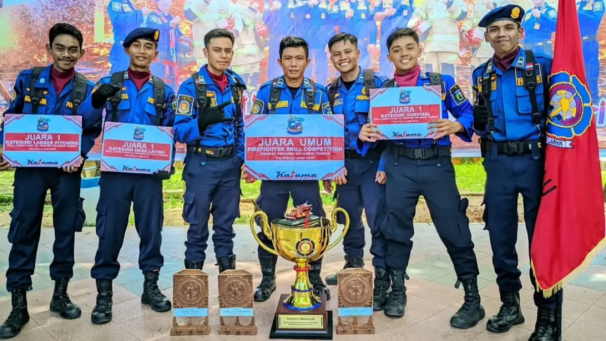 Kontingen Damkar Kota Palu menunjukkan trofi bergilir dan piagam penghargaan setelah meraih Juara Umum Firefighter Skill Competition Tingkat Provinsi Sulawesi Tengah 2026 di Kabupaten Tolitoli. Tim Damkar Palu menyapu bersih tiga kategori lomba, yakni Ladder Pitching, Nose Laying, dan Survival. (FOTO: DAMKAR KOTA PALU)