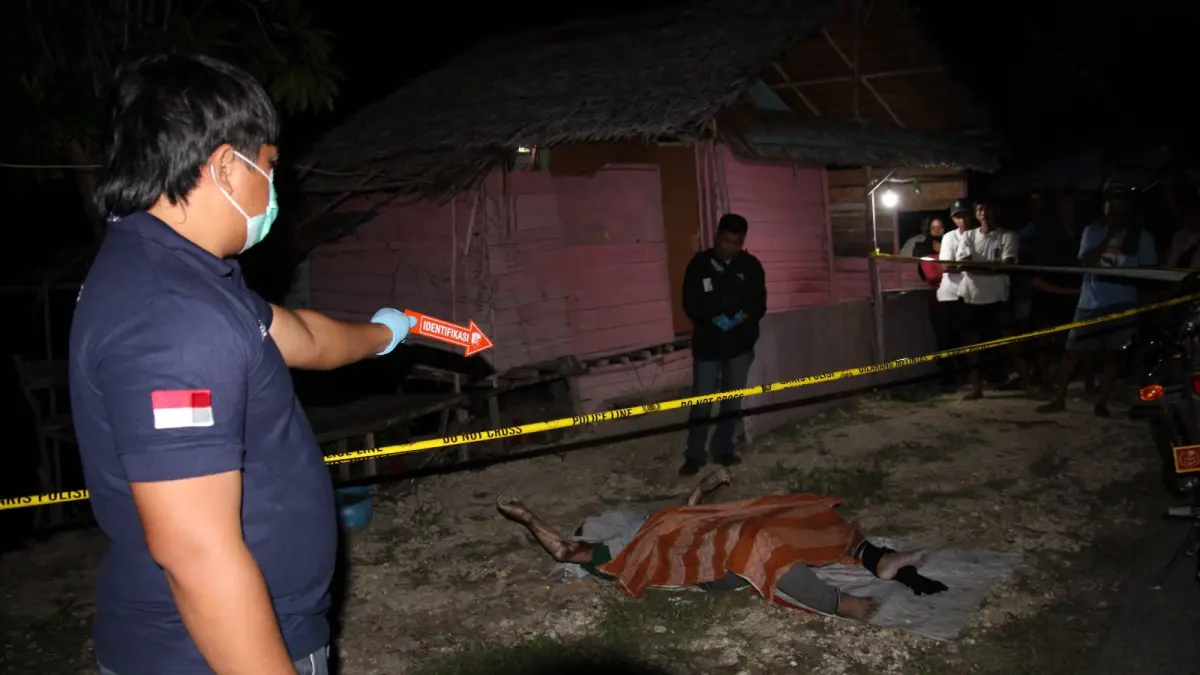 MAYAT: Salah seorang petugas Inafis Polres Banggai, sedang menunjuk sesosok mayat yang baru saja di evakuasi setelah tewas di sekitar pantai.(FOTO: NENDRA PRASETYA/RADAR PALU).