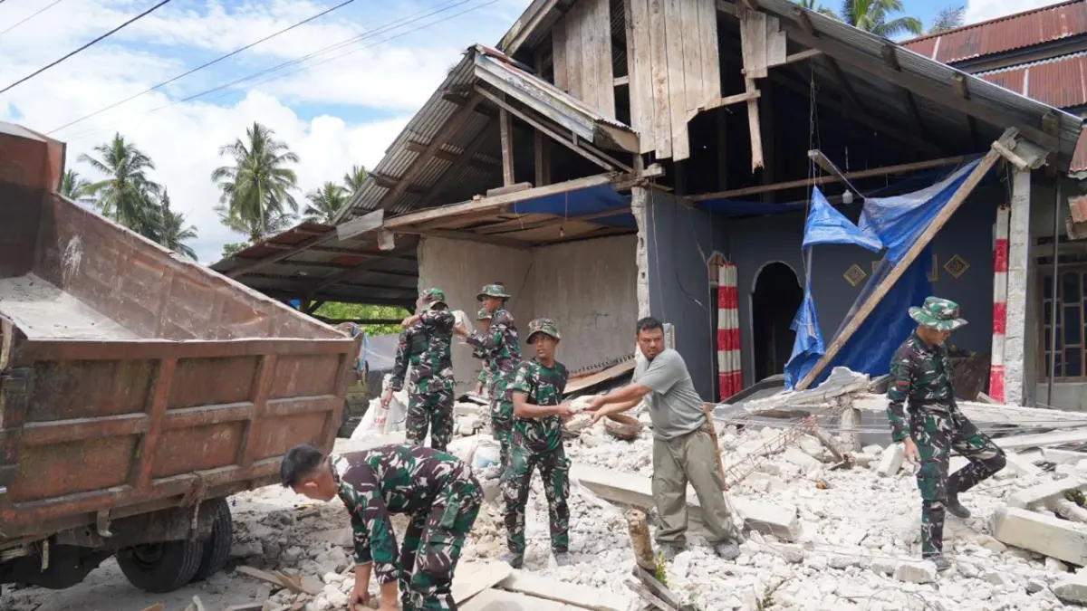 Prajurit Yon TP 873/Mareso Masagena bersama warga membersihkan puing-puing bangunan yang roboh akibat gempa bumi di Desa Kamarora, Kecamatan Nokilalaki, Kabupaten Sigi, Selasa (16/6/2026).
