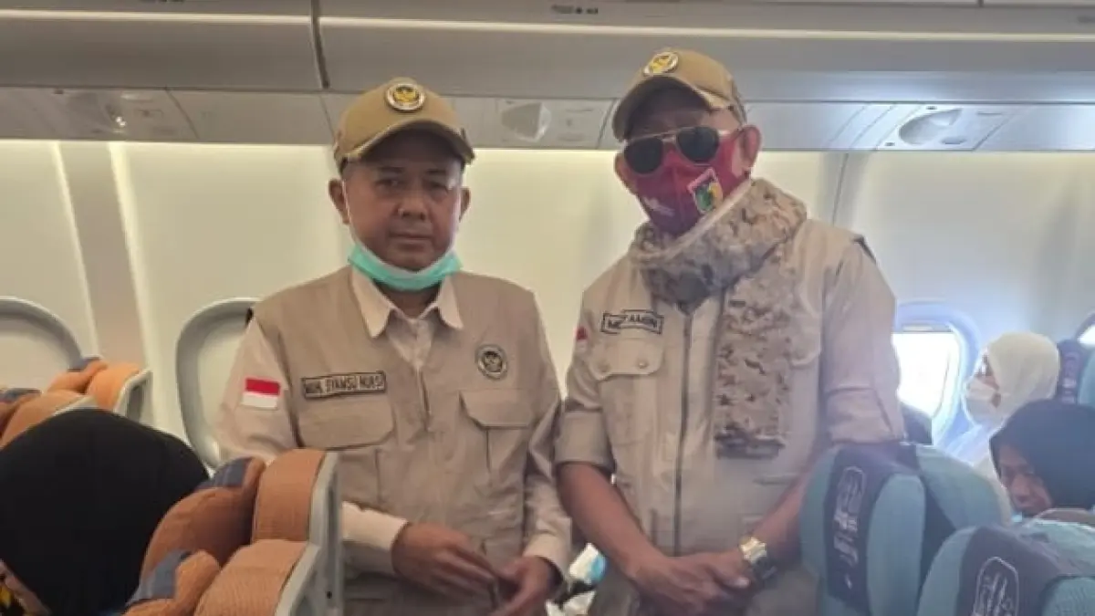 JENAZAH: Petugas Haji dari PT Babussalam , H. Mustamin Umar (kanan) dan Kabid Kamad Kanwil Kemenag Sulteng H. Syamsu Nursi, saat mengurus jenazah almarhuma Ruina Ugu Amu, di pesawat yang sedang menuju Indoensia.(FOTO: ISTIMEWA/RADAR PALU).
