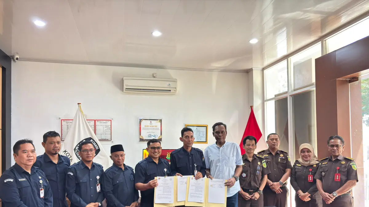 Ketua KPU Kota Palu, Idrus, bersama Kepala Kejaksaan Negeri Palu, Mohamad Rohmadi, menunjukkan dokumen nota kesepahaman (MoU) yang telah ditandatangani di Kantor KPU Kota Palu, Selasa (23/6/2026).