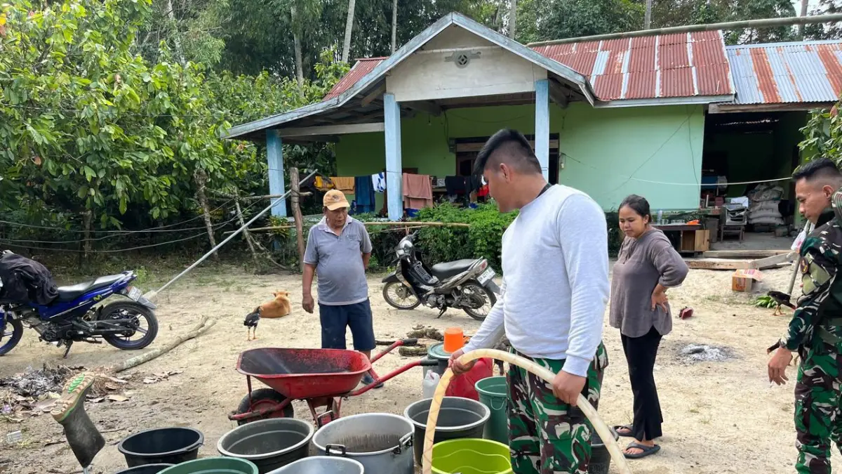 Personel Kodam XXIII/Palaka Wira mengisi bak penampungan air milik warga menggunakan mobil tangki saat menyalurkan bantuan air bersih di Desa Kamarora, Kecamatan Nokilalaki, Kabupaten Sigi, Senin (22/6/2026).