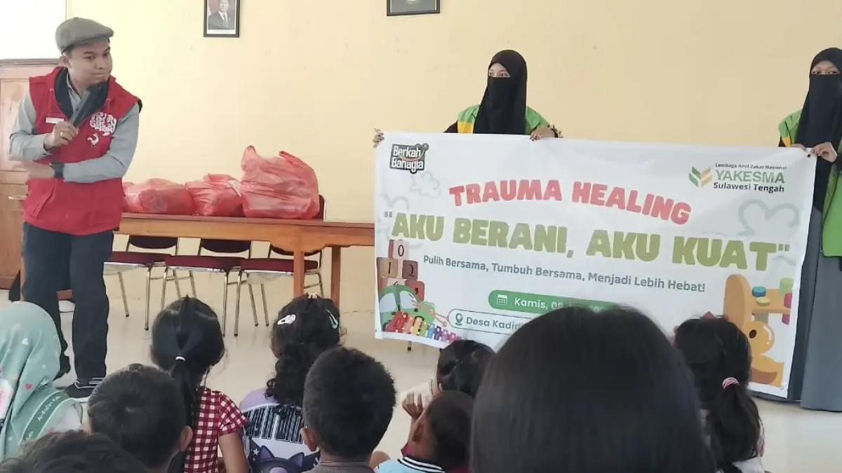 OBATI TRAUMA: Sesi dongeng yang dibawakan Tim Kampung Dongeng Kota Palu bersama pendongeng Indrid (paling kiri) dalam kegiatan Truma Healing “Aku Berani, Aku Kuat” yang dilaksanakan oleh Yakesma Sulteng di Desa Kadidia pada Kamis (9/7/2027).(Foto: Dokumentasi Yakesma Sulteng)