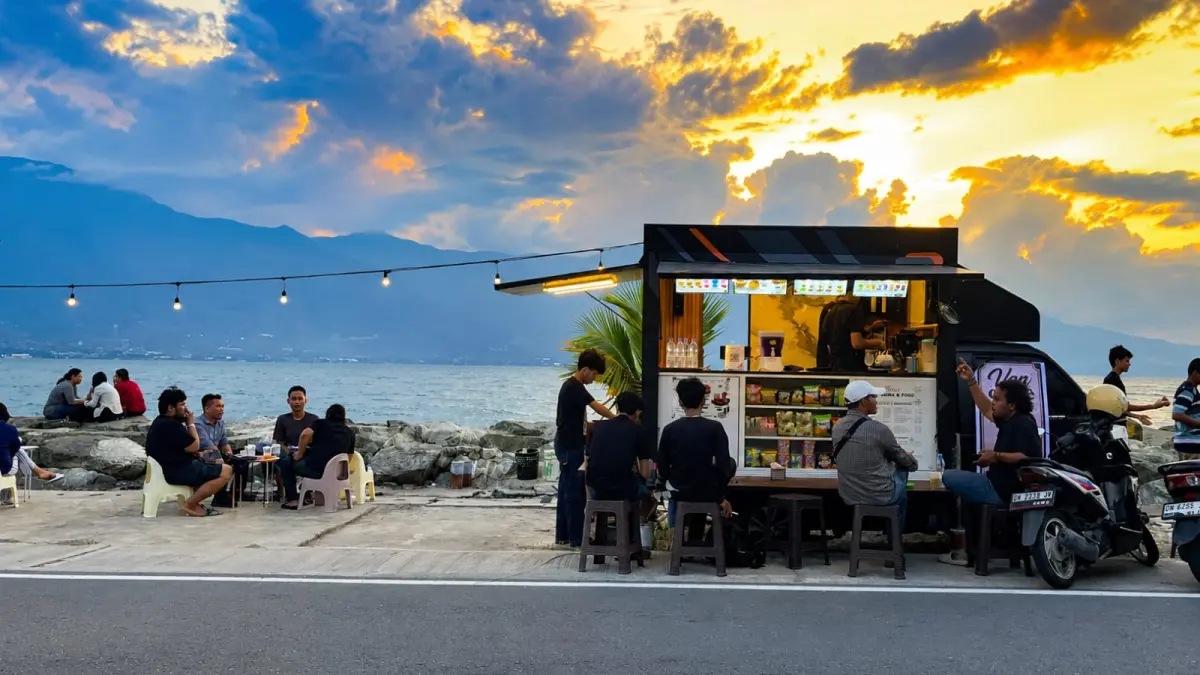 Pengunjung menikmati suasana senja di Van Coffee, kedai kopi berbentuk mobil pick up di kawasan Teluk Palu yang menawarkan panorama laut dan beragam menu dengan harga terjangkau. FOTO: ANNISA NURUL WIBDY&nbsp;