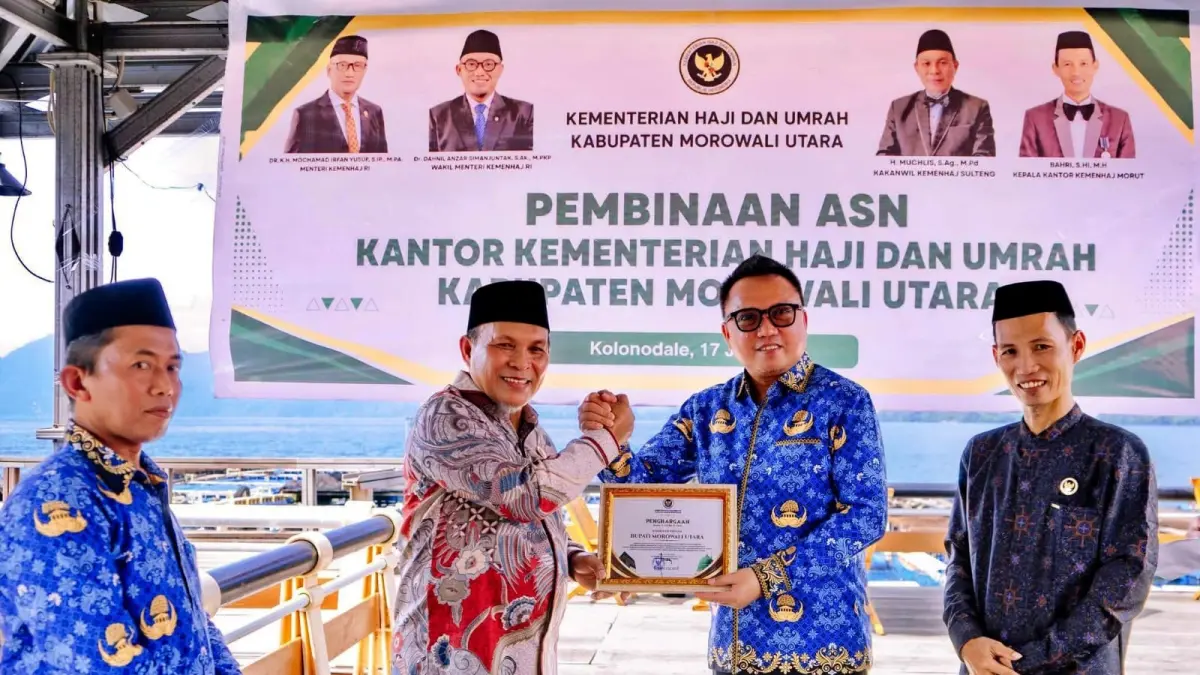 PIAGAM: Kakanwil Kemenhaj Provinsi Sulawesi Tengah H. Muchlis menyerahkan piagam penghargaan Menteri Haji dan Umrah Mochamad Irfan Yusuf kepada Bupati Morowali Utara Delis Julkarson Hehi, Jumat (17/7/2026). (FOTO: ISTIMEWA/RADAR PALU)