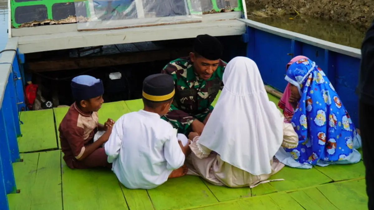 Di sela pelaksanaan TMMD Ke-129, Prada Jefrin memanfaatkan waktu luang untuk mengajarkan mengaji kepada anak-anak di Desa Polewali.&nbsp;