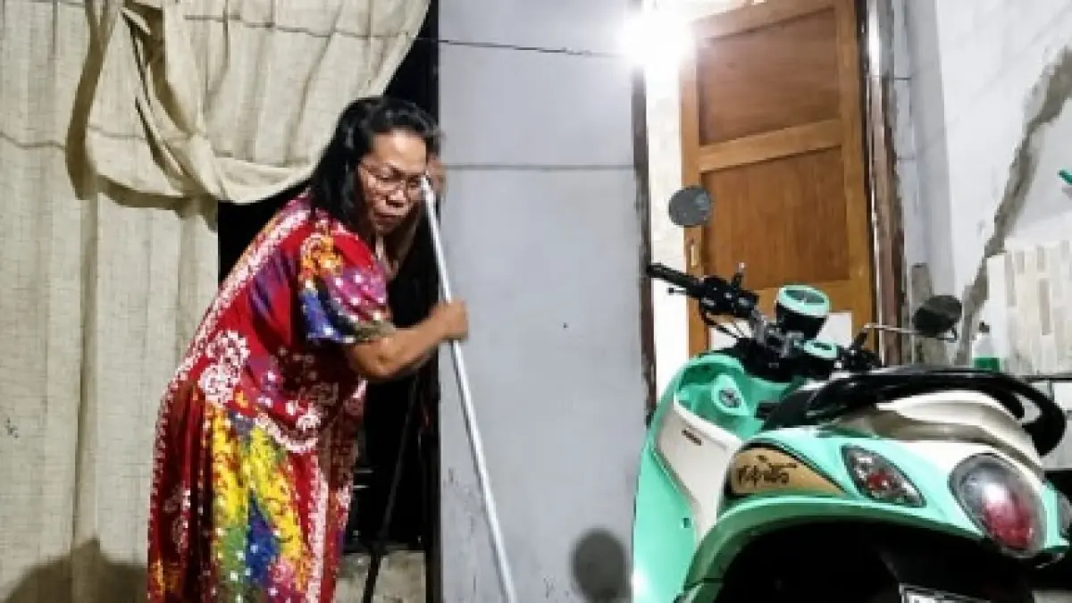 Seorang warga bantara sungai Pondo Kota Palu membersihkan air bercampur lumpah yang meluap akibat banjir dini hari, Rabu (29/7/2026). (Tangkapan layar video)