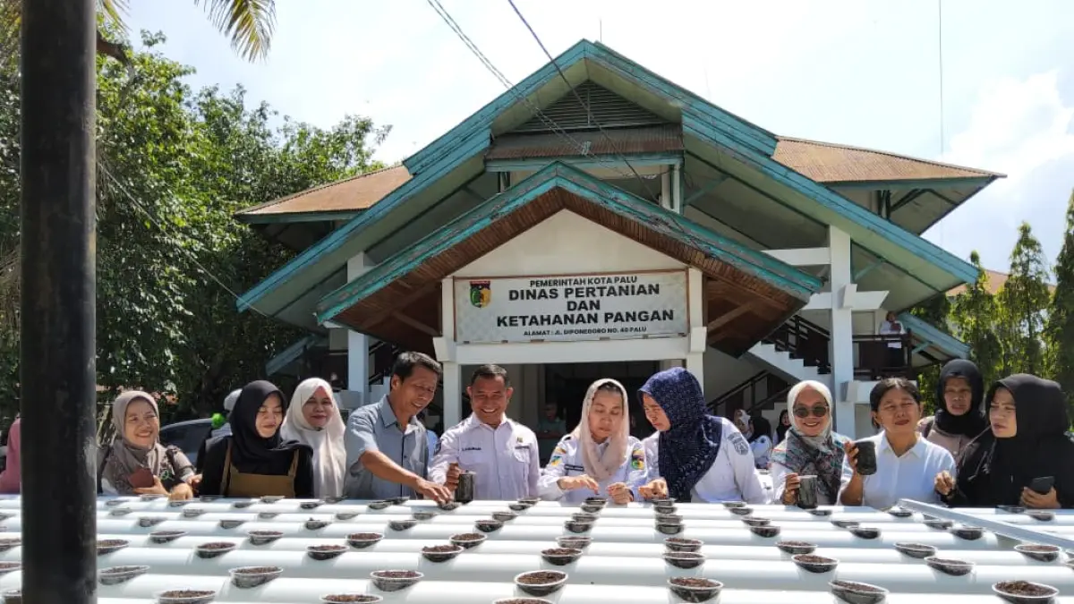 Wakil Wali Kota Palu, Imelda Liliana Muhidin lakukan penebaran benih pada kolam unit hidroganik di DPKP Kota Palu. (DOK: Humas Pemkot Palu)