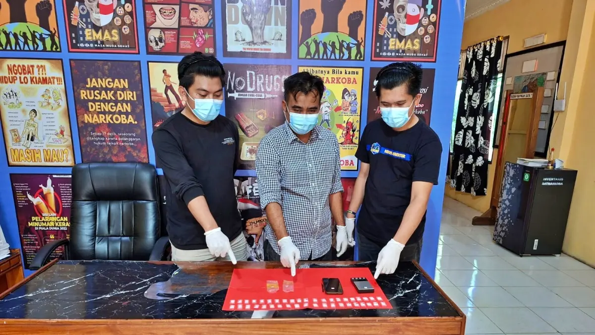 BABUK - Kasatresnarkoba Polres Morowali Utara AKP Ahmad Sadat (tengah) menunjukkan 56 paket sabu sitaan dalam operasi penindakan kurun waktu sepekan terakhir, Rabu (5/7/2026). (FOTO: ISTIMEWA/RADAR PALU)