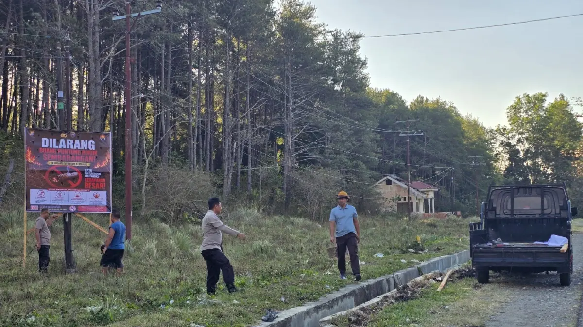 IMBAUAN: Aparat kepolisian Banggai, sedang memasang spanduk melarang membakar, dan dilarang merokok di dalam kawasan hutan.(FOTO: NENDRA PRASETYA/RADAR PALU).