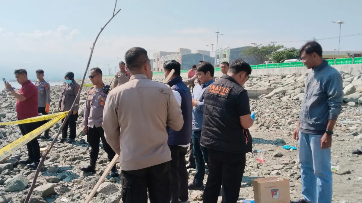 Petugas kepolisian bersama warga berada di lokasi penemuan sesosok jenazah perempuan di pesisir Pantai Kelurahan Lere, Kecamatan Palu Barat.