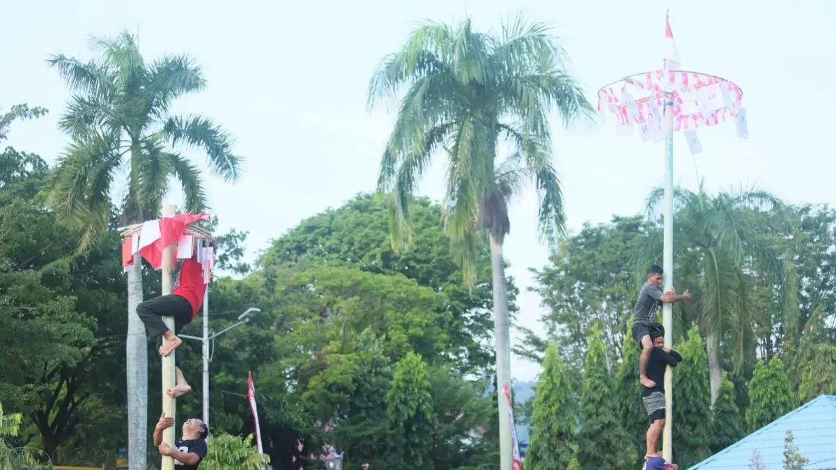 PINANG: Suasana lomba panjat pohon pinang di Kabupaten Poso.(FOTO: BUDIYANTO WIHARTO/RADAR PALU)&nbsp;