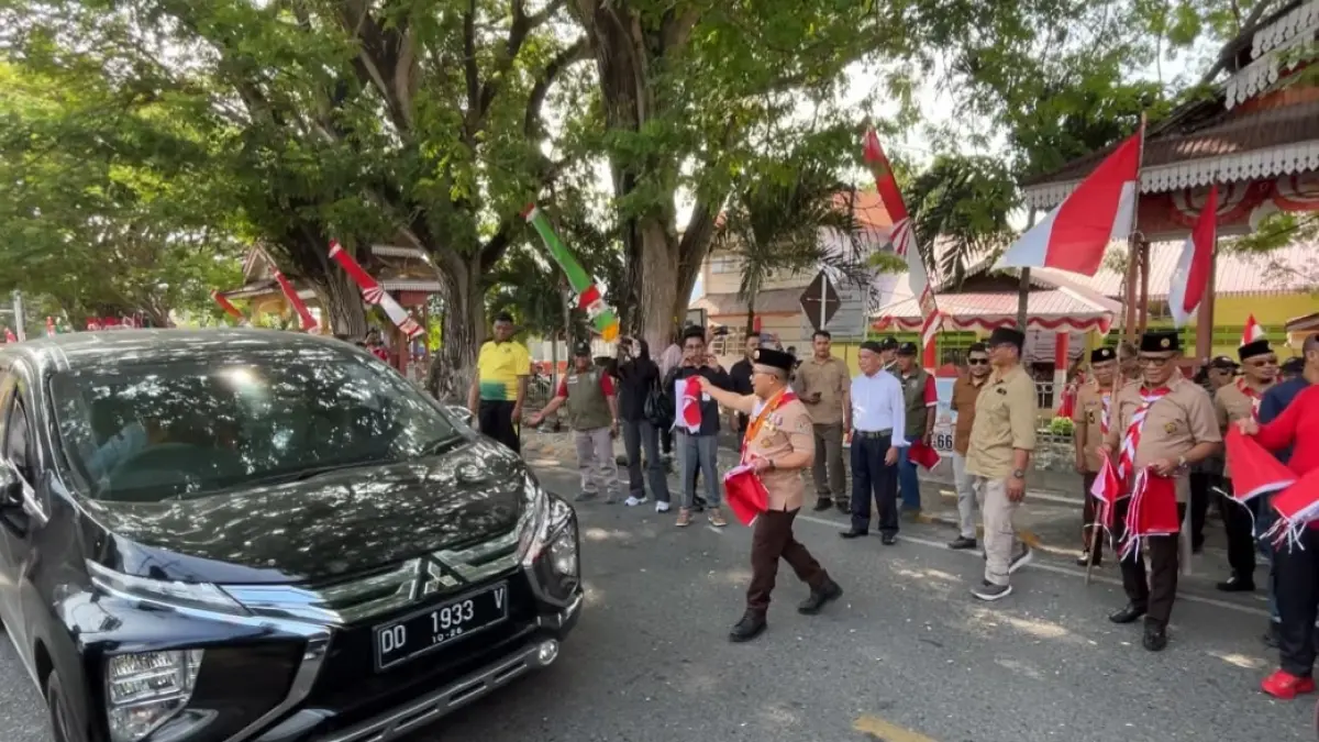 BENDERA: Bupati Banggai, Amirudin Tamoreka terlihat sedang membagikan bendera kepada warga kota Luwuk, di Kabupaten Banggai.(FOTO: NENDRA PRASETYA/RADAR PALU).