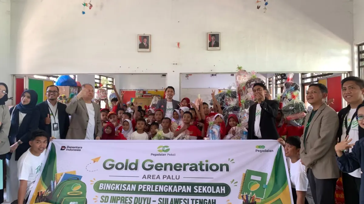 Deputi Bisnis PT. Pegadaian Area Palu, Putera Aspin Rahmatullah dan pegawai PT. Pegadaian berfoto bersama siswa/i SD Inpres Duyu. (Rina/Radar Palu).