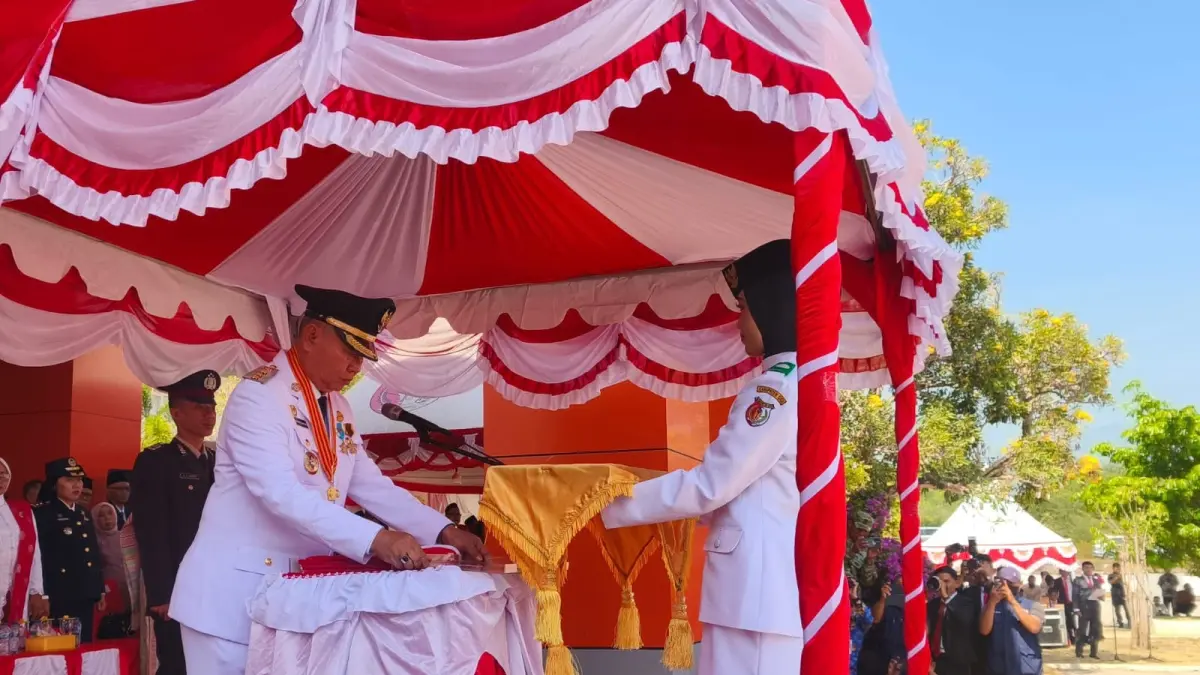 BENDERA: Bupati Sigi, Moh. Rizal Intjenae menyerahkan bendera merah putih di peringatan  ke-81 kemerdekaan Republik Indonesia di halaman Kantor Bupati Sigi, Senin (17/8/2026).(FOTO: ANGEL SUMBARA/RADAR PALU).