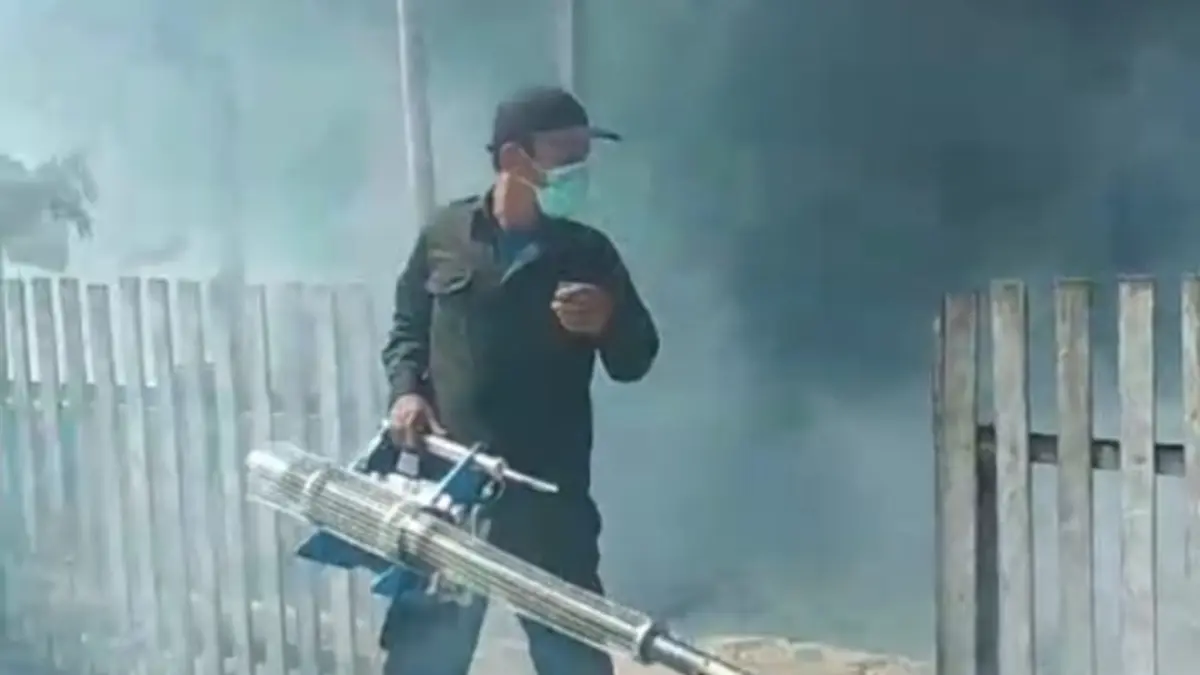 FOGGING: Salah seorang petugas sedang melakukan fogging di rumah warga di Touna.(FOTO: HERIYANTO LIMAHHU/RADAR PALU).